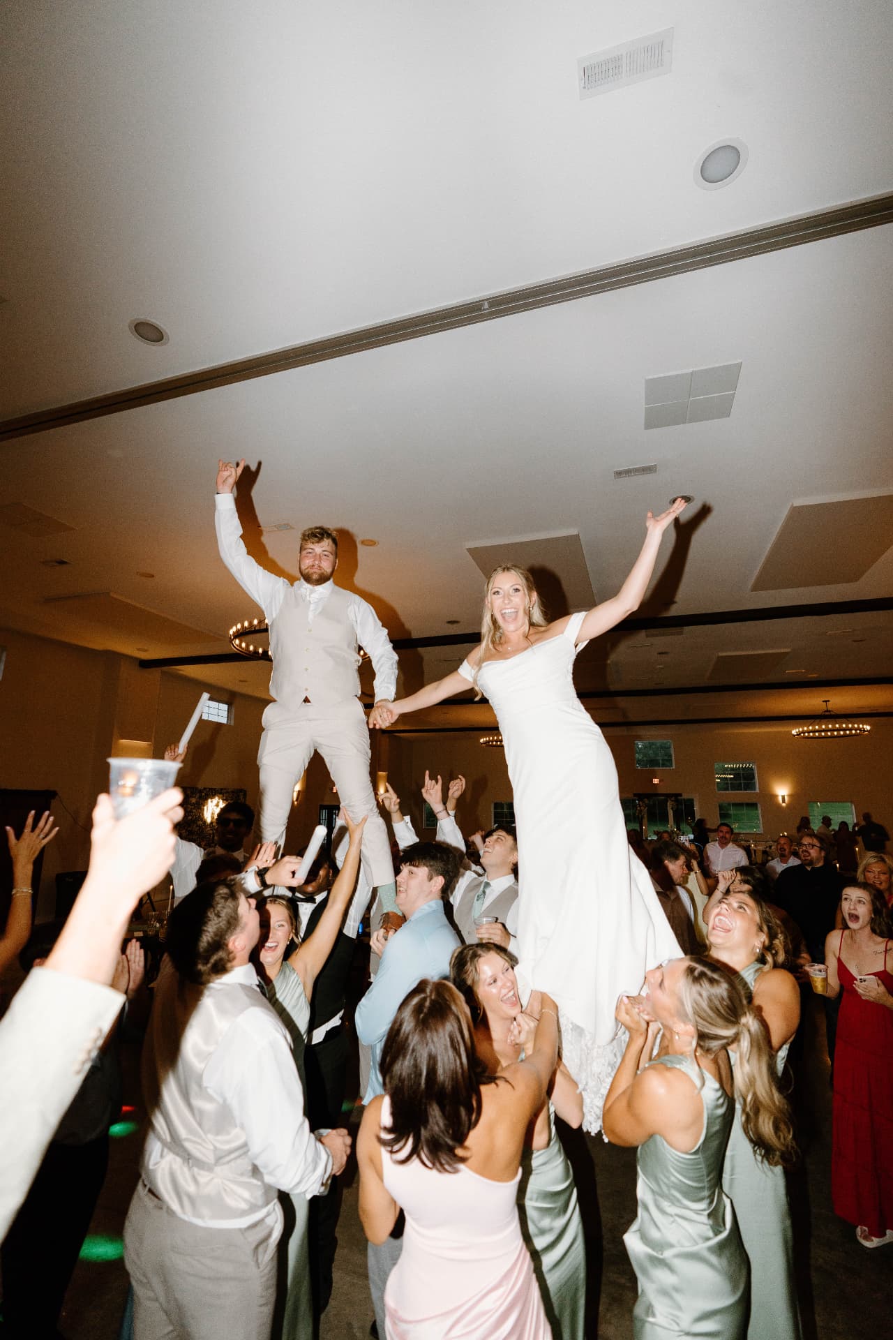 Austyn and Keegan lifted above the dance floor with hands raised at their Williamsburg reception